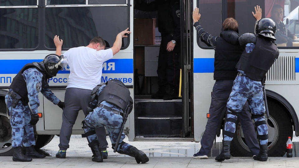 Des agents des forces de l'ordre arrêtent des manifestants à Moscou.