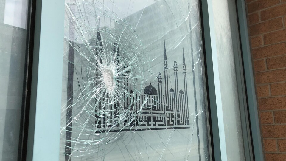 La vitre fracassée d'une mosquée.