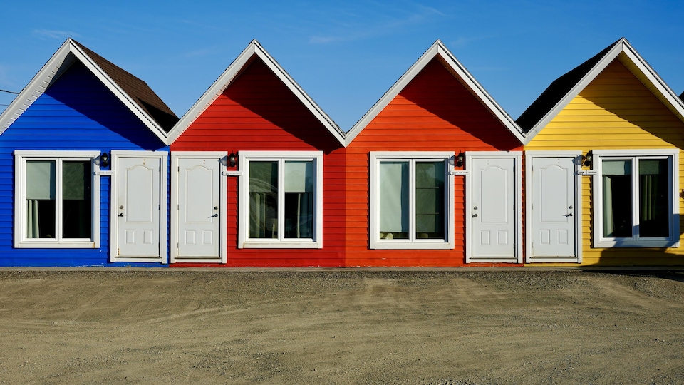 De petites cabines de motel aux toits pointus sont construites en rangée.