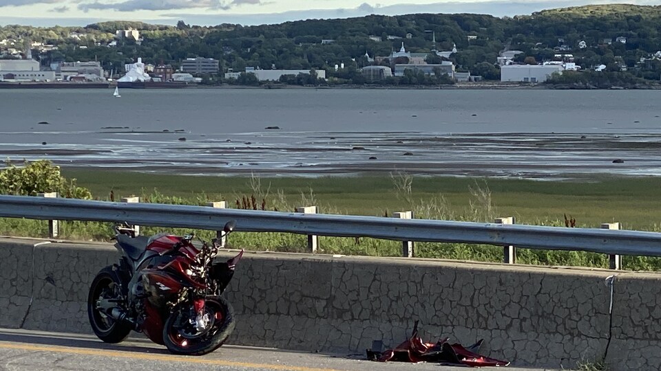 Une moto brisée sur le bord d'une autoroute.