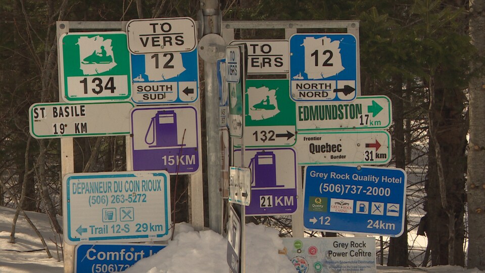 Des affiches d'information près d'un sentier de motoneige.