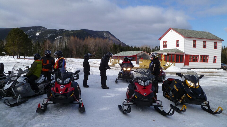 Motoneigistes devant le Relais de la cache