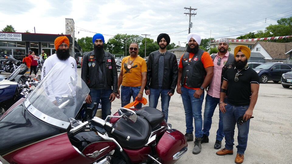 Des hommes Sikhs posent à côté de leurs motos. 