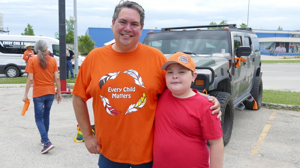 Kyle Mason porte un chandail orange "Every Child Matters", il pose avec son jeune fils Elijah Mason. 