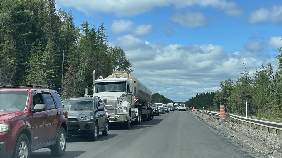 Des dizaines de véhicules sont arrêtés sur la route d'un côté. De l'autre, quelques voitures peuvent circuler dans la zone de travaux.