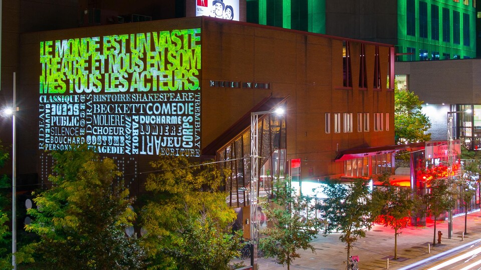 Des mots et des noms d'auteurs sont écrits sur le mur d'un édifice.