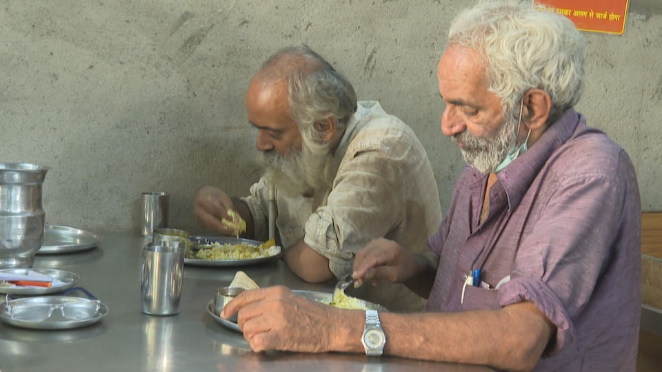 Dois homens comendo lado a lado.