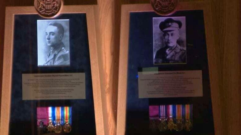 Deux des quinze soldats du mur d'excellence avec leurs médailles et une plaque en or qui raconte leur histoire.
