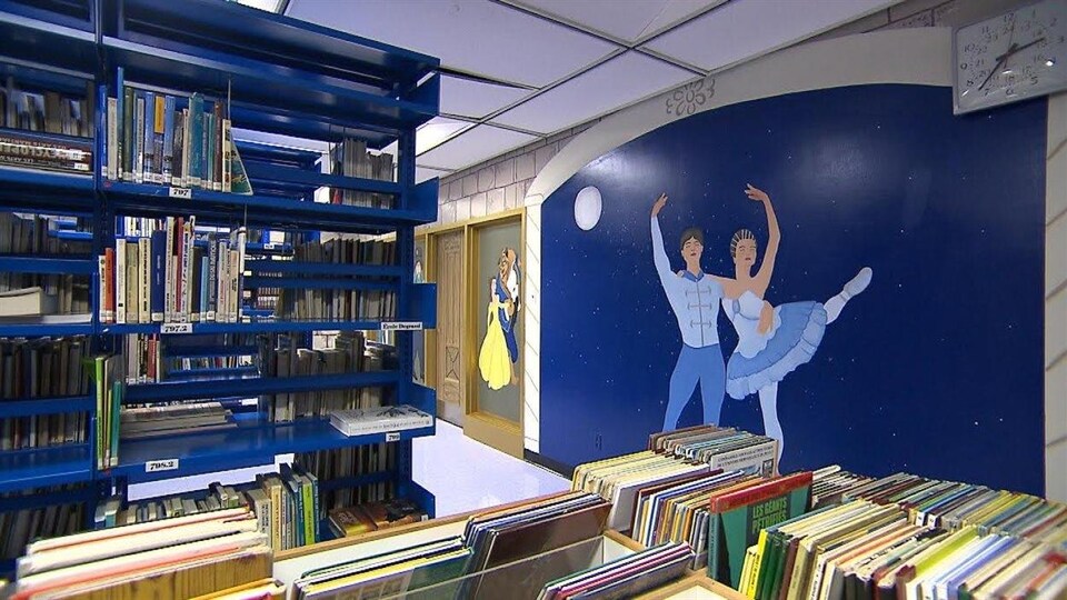 Dans une bibliothèque, une murale sur laquelle on voit un danseur et une danseuse de ballet.