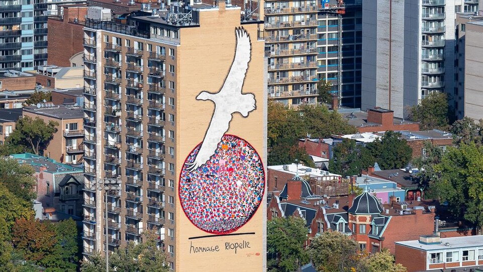 Photo de Montréal montrant une façade ornée d'une grande œuvre murale. 