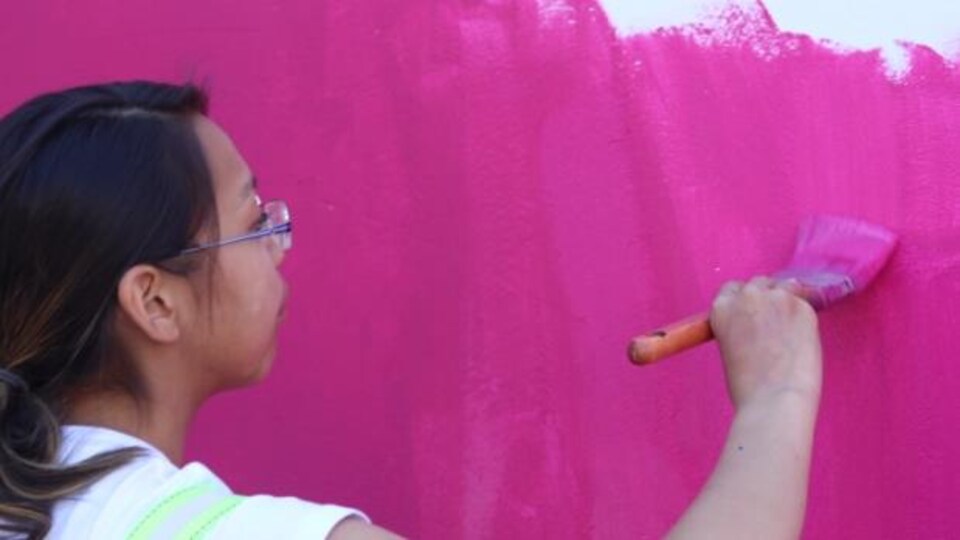 Une jeune artiste en train de peindre.