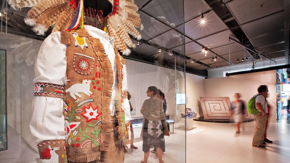 Un vêtement traditionnel autochtone est exposé dans une salle de musée.