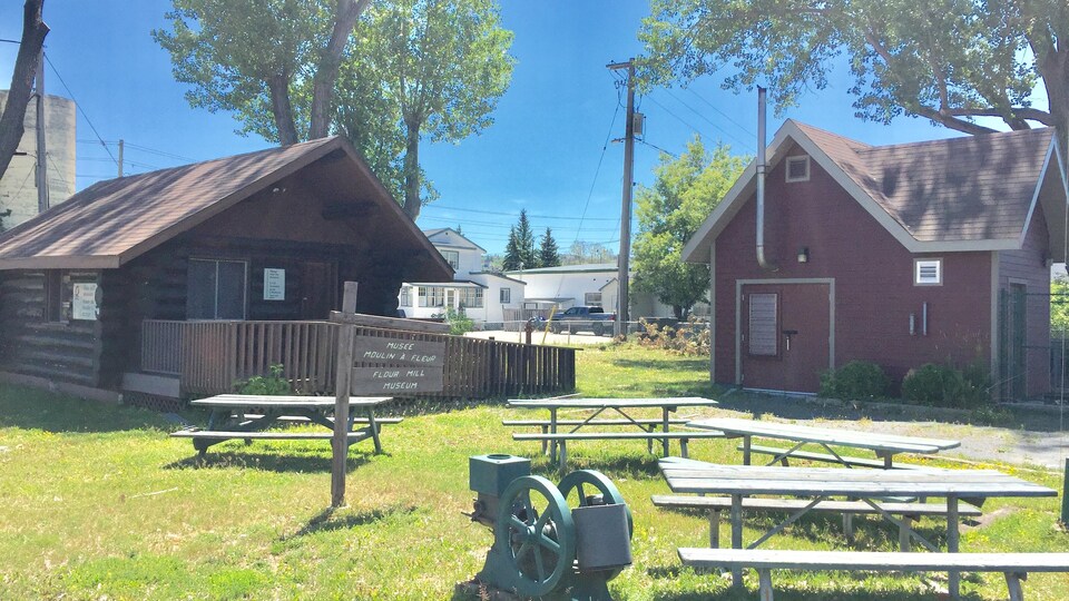 Un moulin, des bancs, une cabane et une maison.