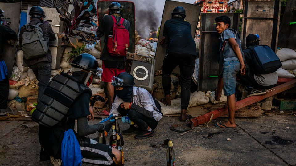 Des manifestants se préparent à utiliser des cocktails Molotov contre les forces de la junte militaire, le 16 mars 2021, à Rangoon, au Myanmar.
