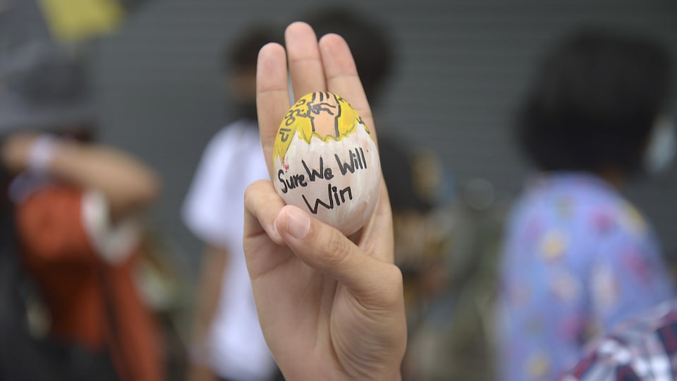 Un manifestant anti-coup d'État tient un œuf de Pâques décoré avec le symbole de résistance à Rangoon.