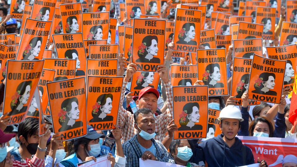 Des manifestants brandissent le portrait d'Aung San Suu Kyi lors d'une manifestation.