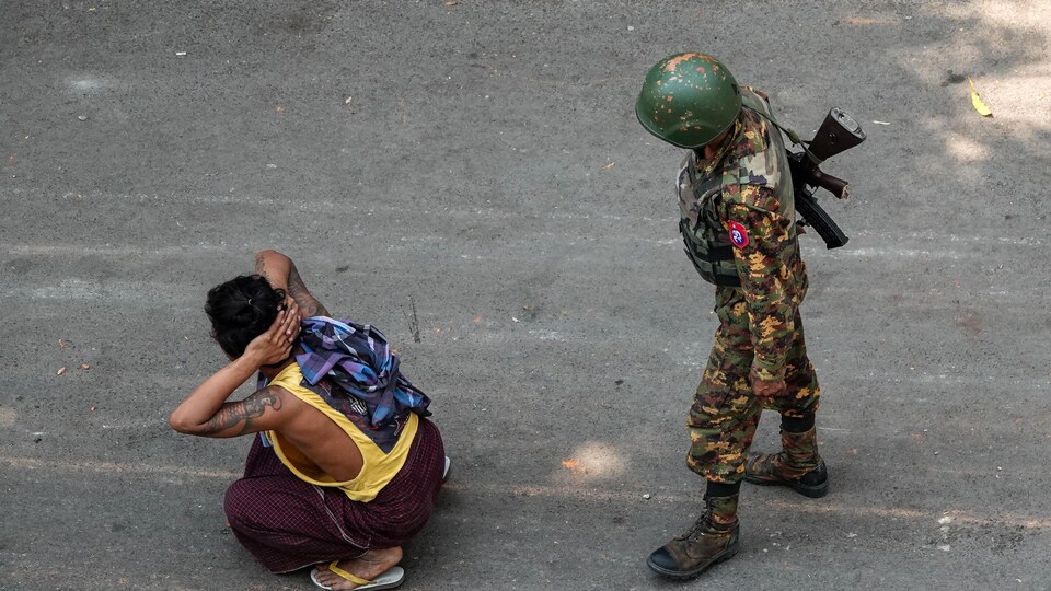 Un soldat birman et un manifestant.