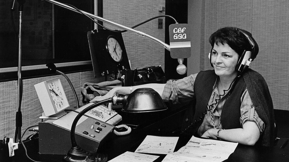 Dans un studio de radio, l'animatrice Myra Cree prend les appels téléphoniques.