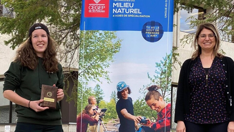 Deux femmes souriantes se trouvent à proximité d'une bannière du Cégep de Saint-Félicien.