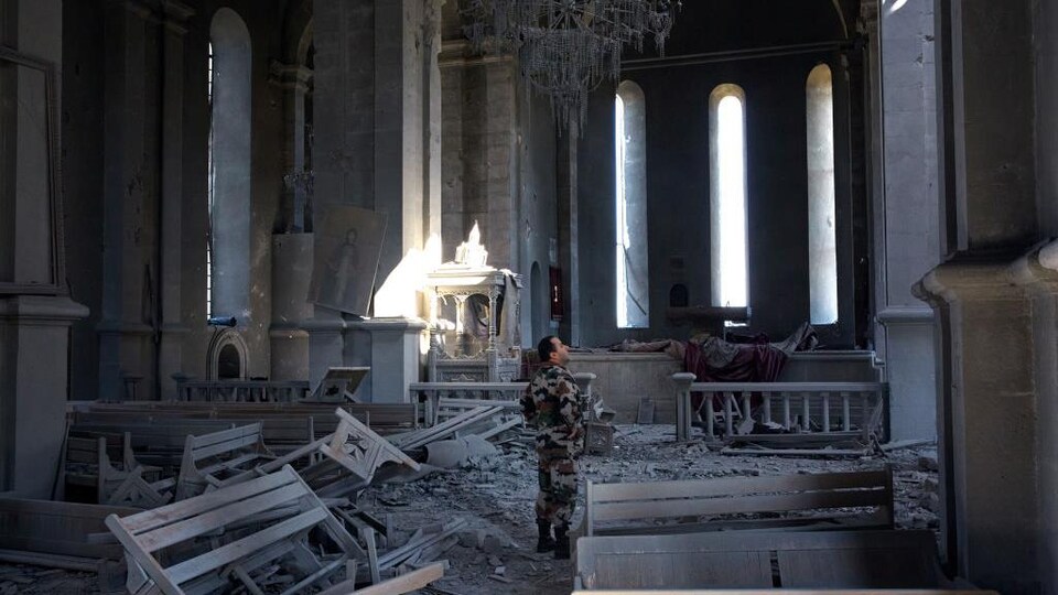 Un soldat regarde les dégâts causés à une église qui a été frappée à deux reprises par un drone, lundi, à Shoushi, dans le Haut-Karabakh.