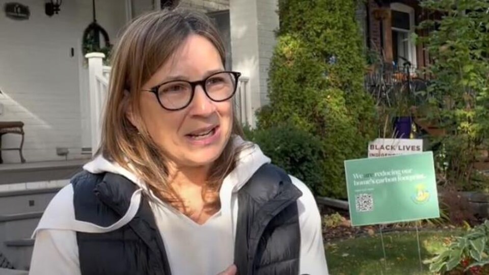 Nancy Tremblay en entrevue devant une maison.