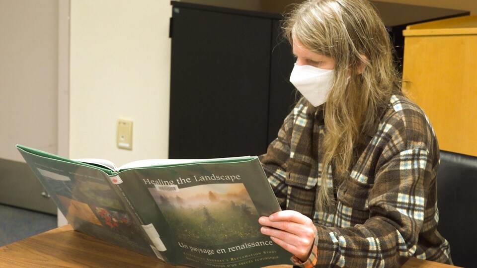Naomi Grant lit un livre qui porte sur l'environnement.