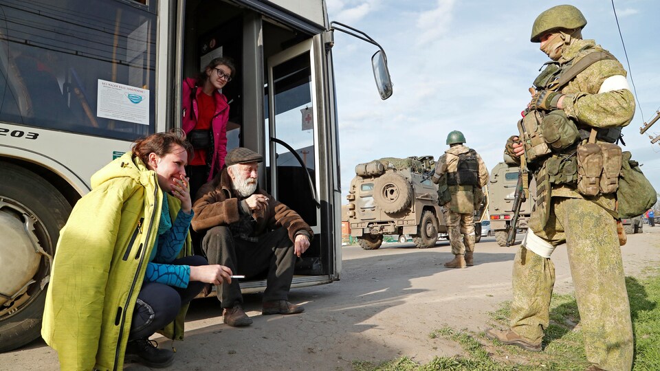 Natalia Ousmanova fume une cigarette avec des soldats ukrainiens et d'autres évacués de Marioupol.