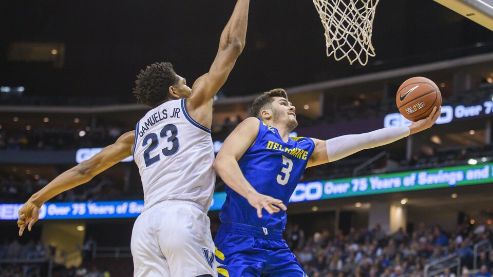 Nate Darling lève le ballon vers le panier dans un match de basketball.