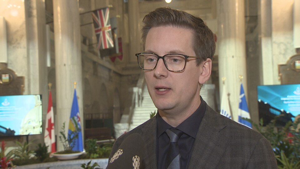Nate Glubish, ministre  de la Technologie et de l'Innovation de l'Alberta, s'exprime devant un micro.