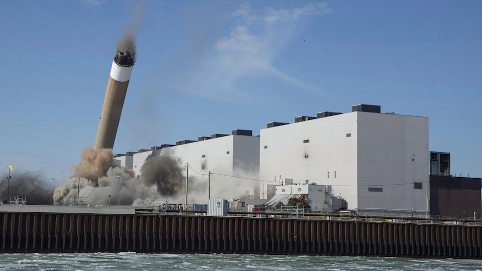 La démolition de la centrale de Nanticoke, dont une cheminée chute dans un nuage de fumée.