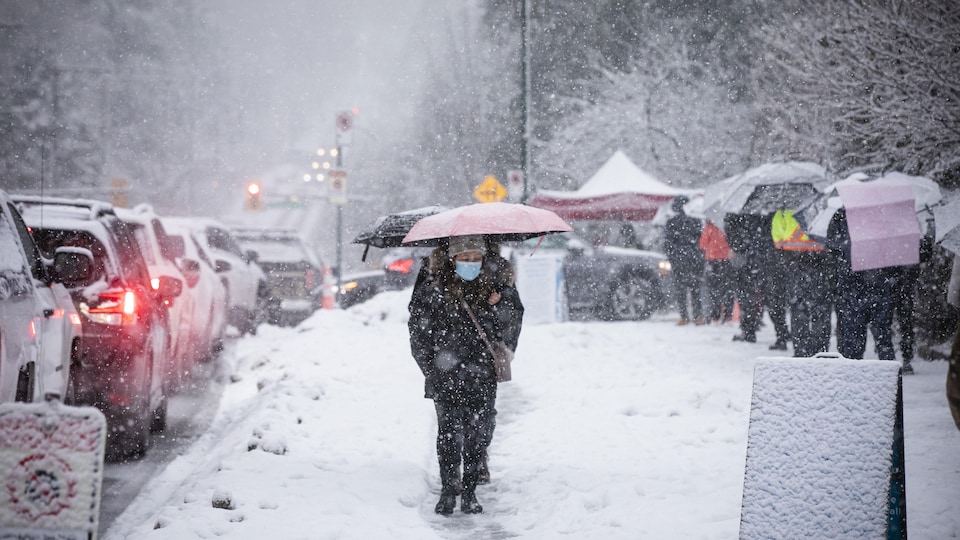 Des dizaines de personnes font la queue sous la neige pour obtenir un test de dépistage à Vancouver le 4 janvier 2022.