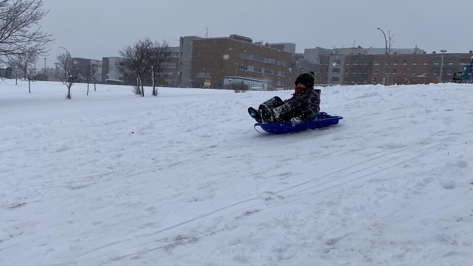 Un jeune glisse dans une pente.