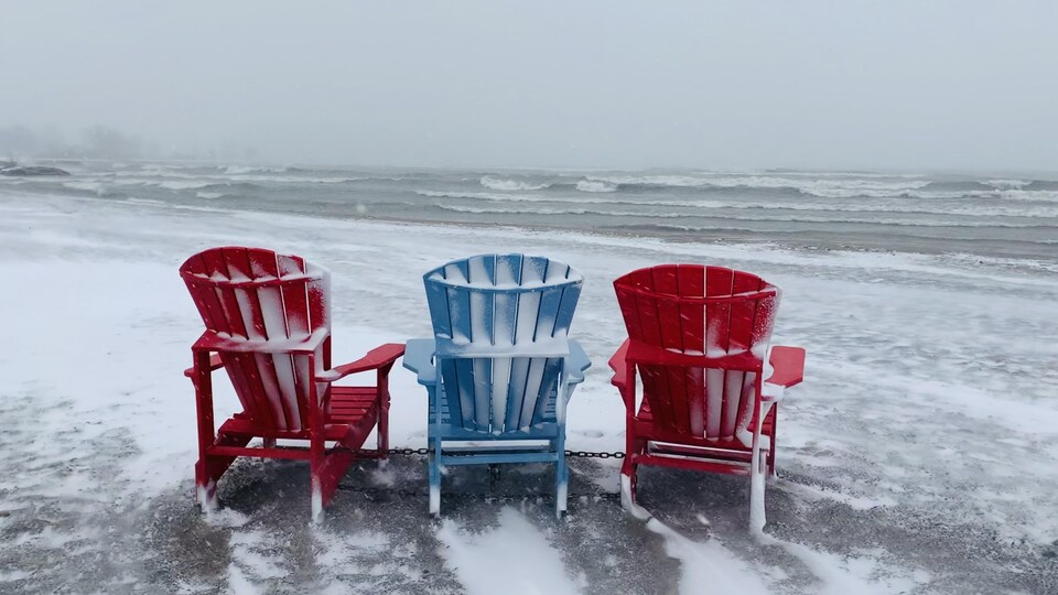 Trois chaises en plastique sur le bord du lac Ontario à Toronto.