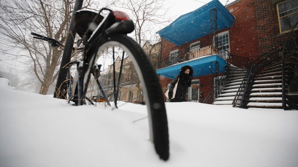 Une femme marche dans la neige à Montréal.