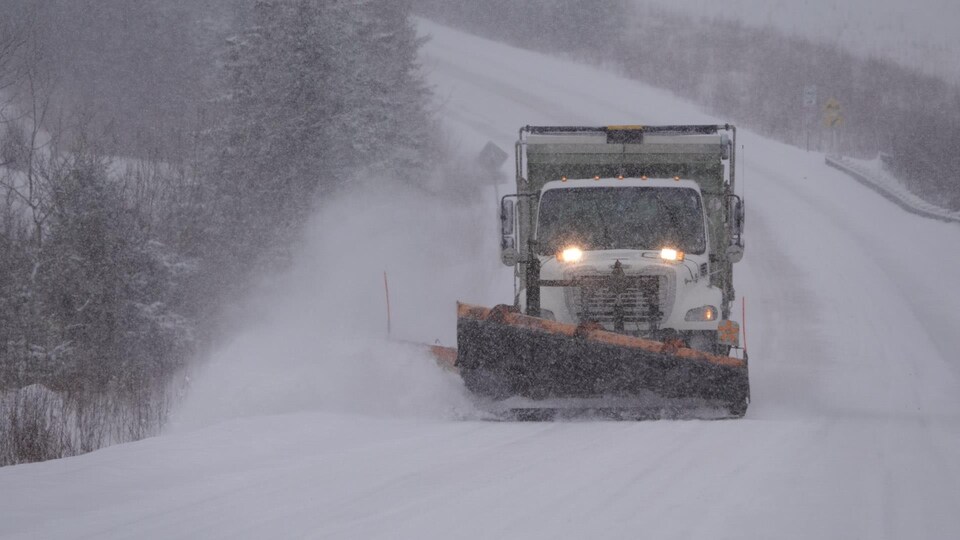 Une déneigeuse pendant une tempête de neige