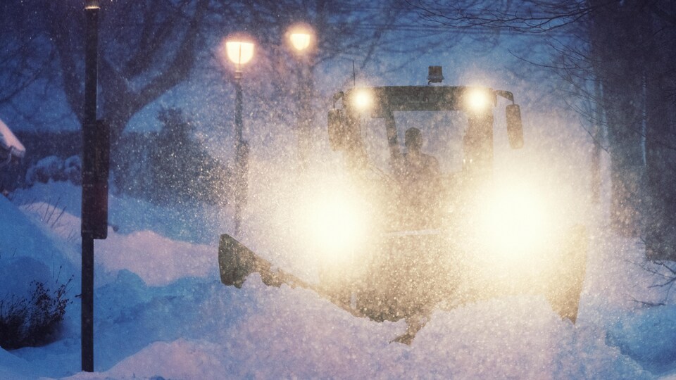 Une déneigeuse déblaie la neige sur un trottoir du quartier nord d'Halifax pendant la nuit.