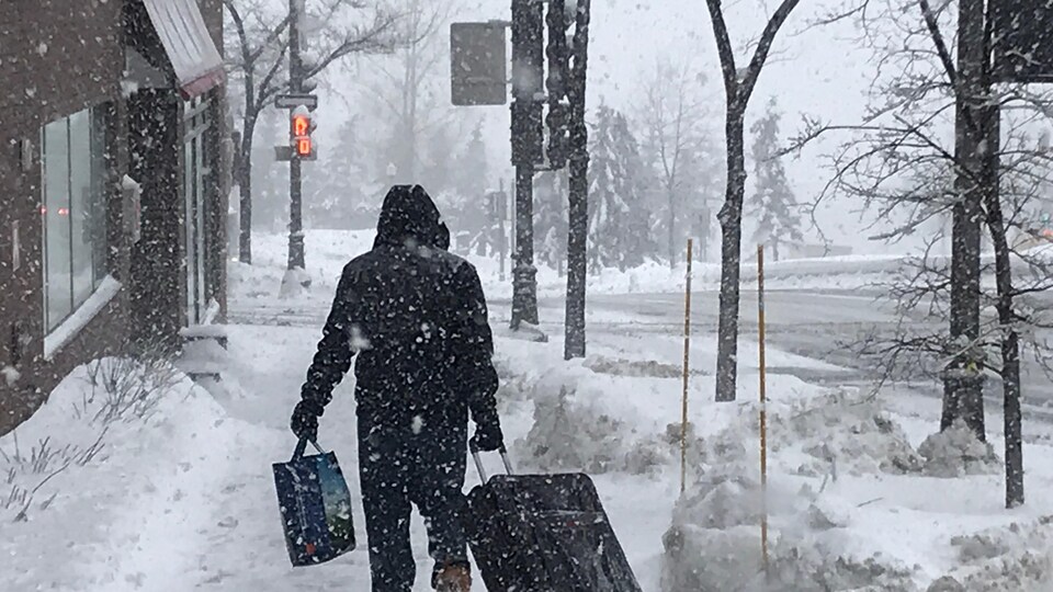 Un homme marche dans la neige