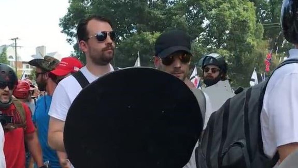 Un homme avec un bouclier dans une manifestation.