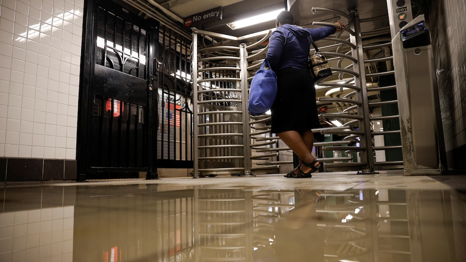 Site neredeyse sular altında kaldığı için metro istasyonunun girişinde bir kadın bekliyor.