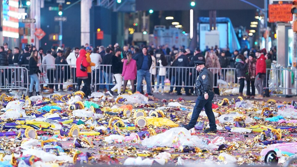 Un policier à Times Square, où les fêtards ont laissé des déchets sur la chaussée après les célébrations du Nouvel An.