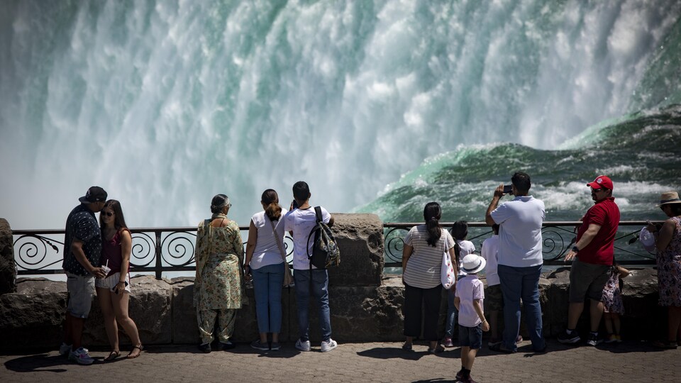 Des touristes prennent des photos des chutes Niagara.