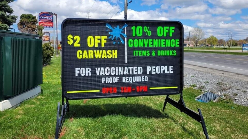 Un panneau sur lequel on peut lire que les clients qui présentent une preuve d'avoir reçu un vaccin contre la COVID-19 peuvent bénéficier de rabais.