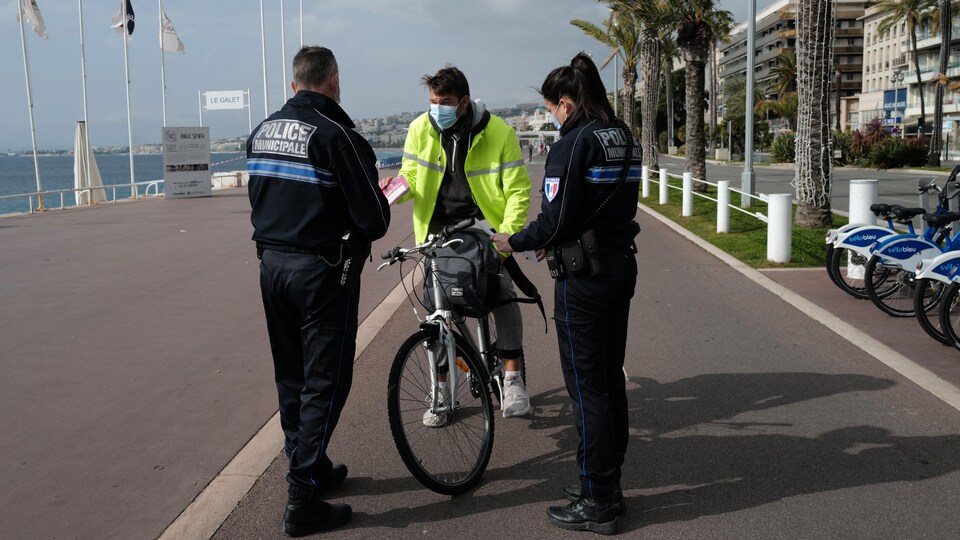 L'homme montre ses papiers aux policiers.