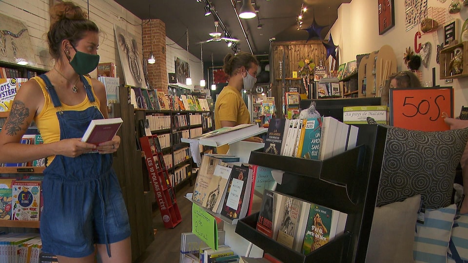 Une jeune femme et un jeune homme dans les rayons de la Chouette librairie.