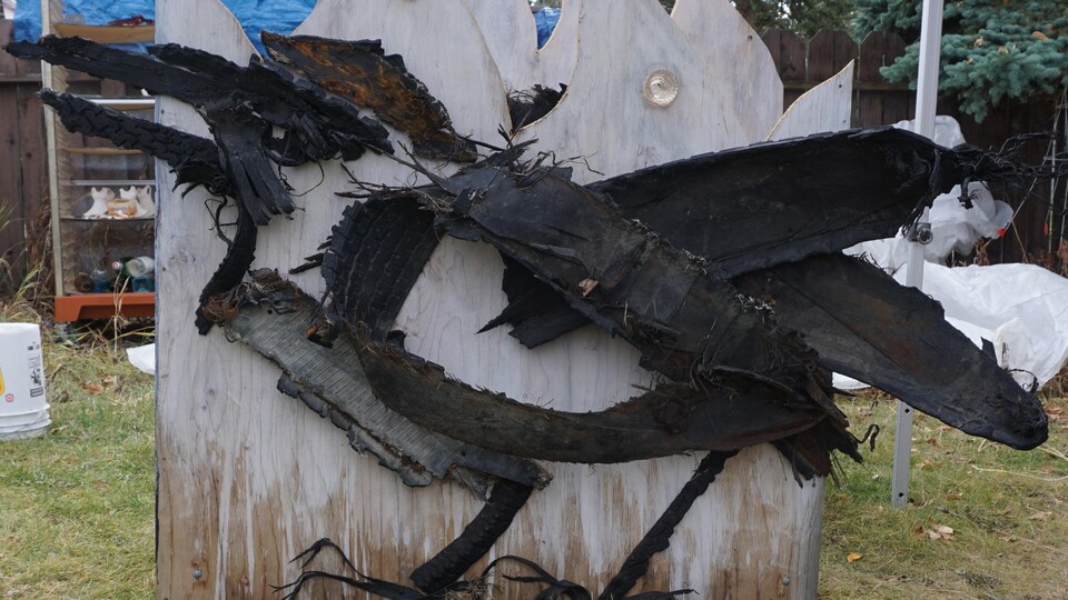 Un panneau en métal avec un dessin de corbeau.