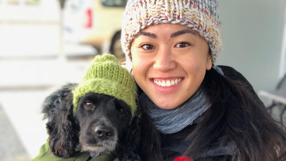 Nicole Chan sourit et tient un chien