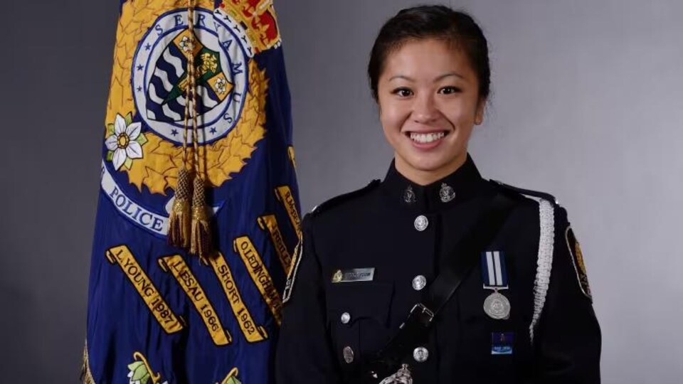 Une jeune femme en uniforme sourit