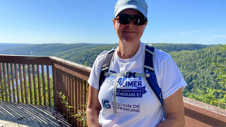 Nicole Lagacé se trouve au belvédère Saint-Alexis, on peut voir des montagnes derrière elle. 