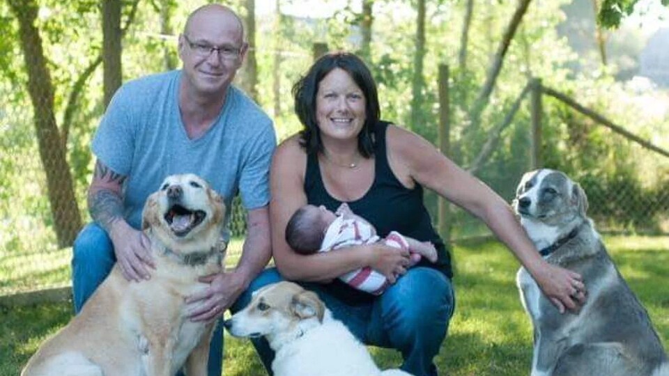 Photo de famille avec trois chiens.
