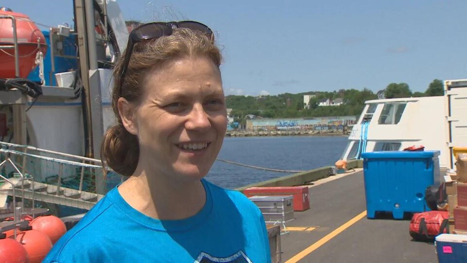 Andrea Niemi en entrevue sur un quai devant le bateau des scientifiques